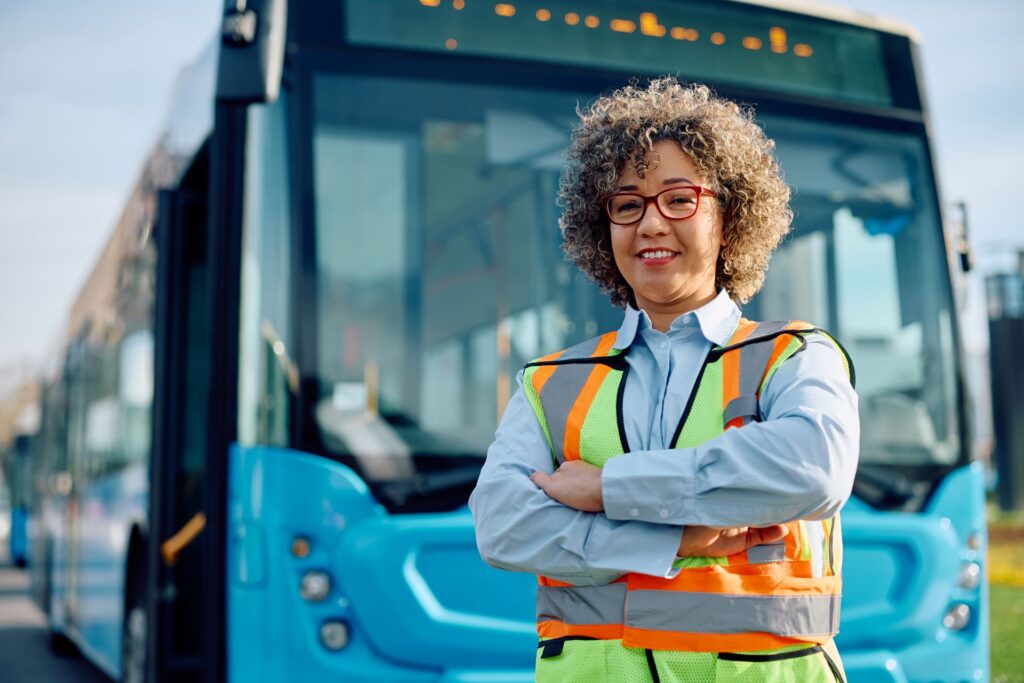 Frau im ÖPNV-Job als Busfahrerin an der Bushaltestelle