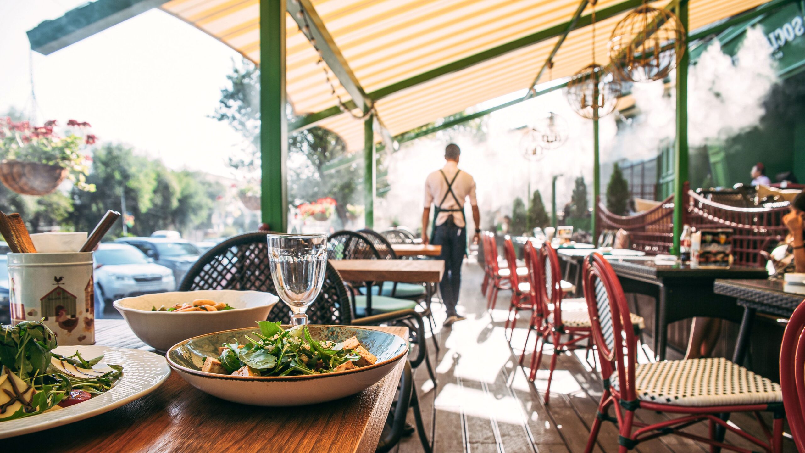 Terrasse im Freien mit serviertem Tisch und Kellner im Sommercafé